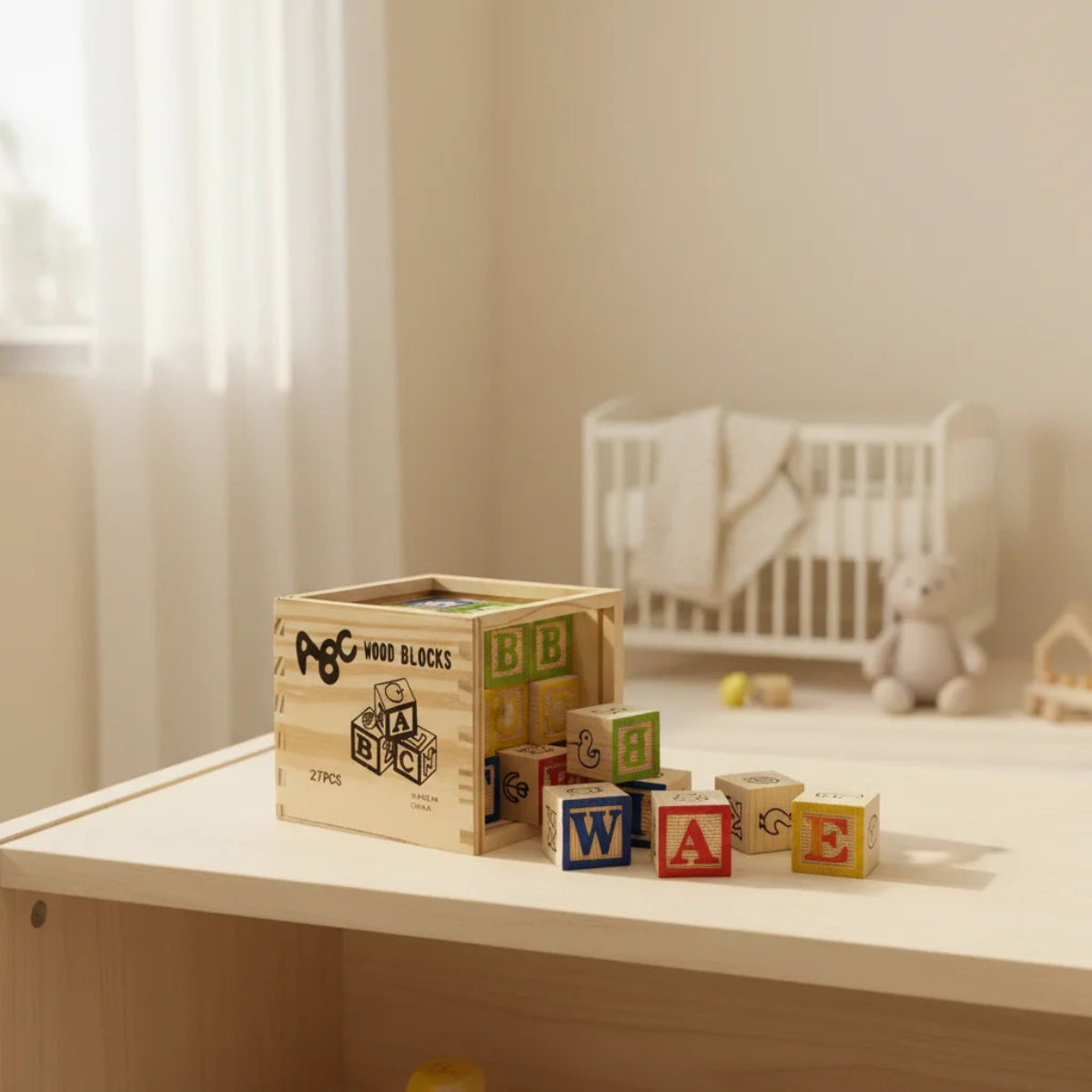 ABC Wood Blocks 27 piece set in engraved pine wooden crate displayed in warm cream nursery setting with white cot colourful letter blocks W A E scattered on white table surface