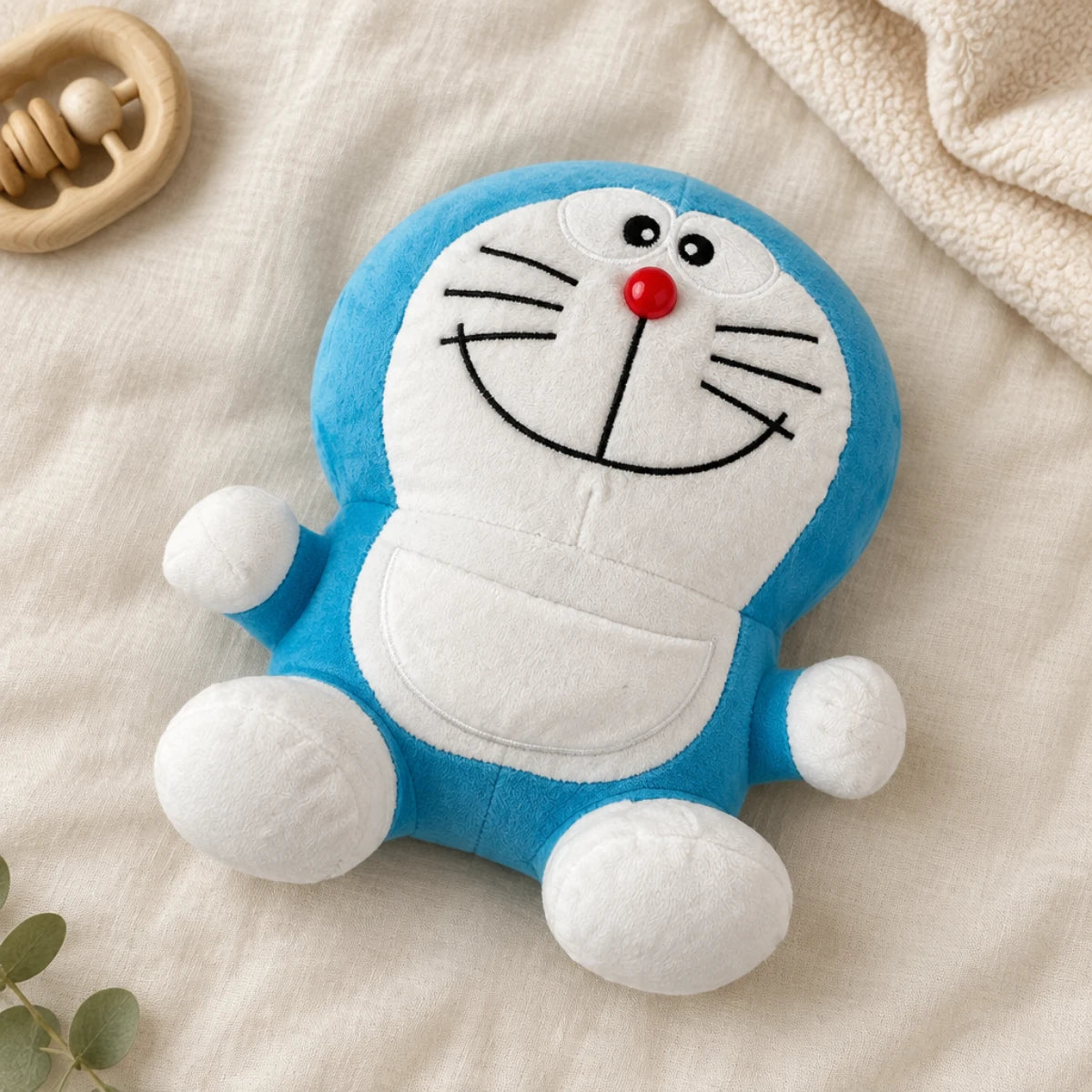 Blue-and-white cat plush displayed on cream bedding beside a wooden toy