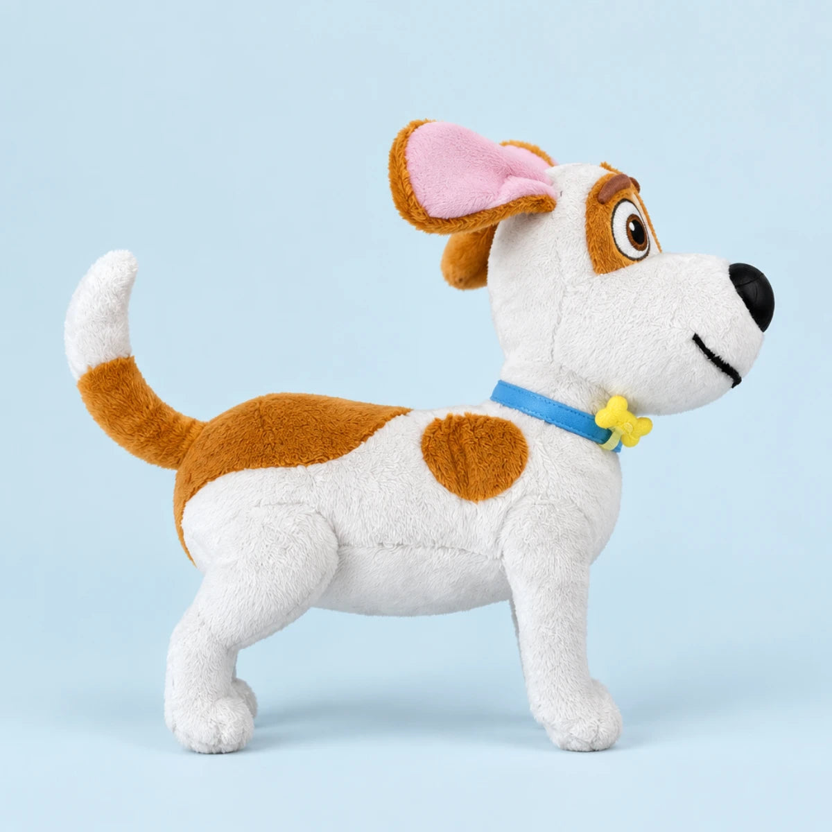 Brown-and-white dog plush with floppy pink ears and blue collar against a pale blue background