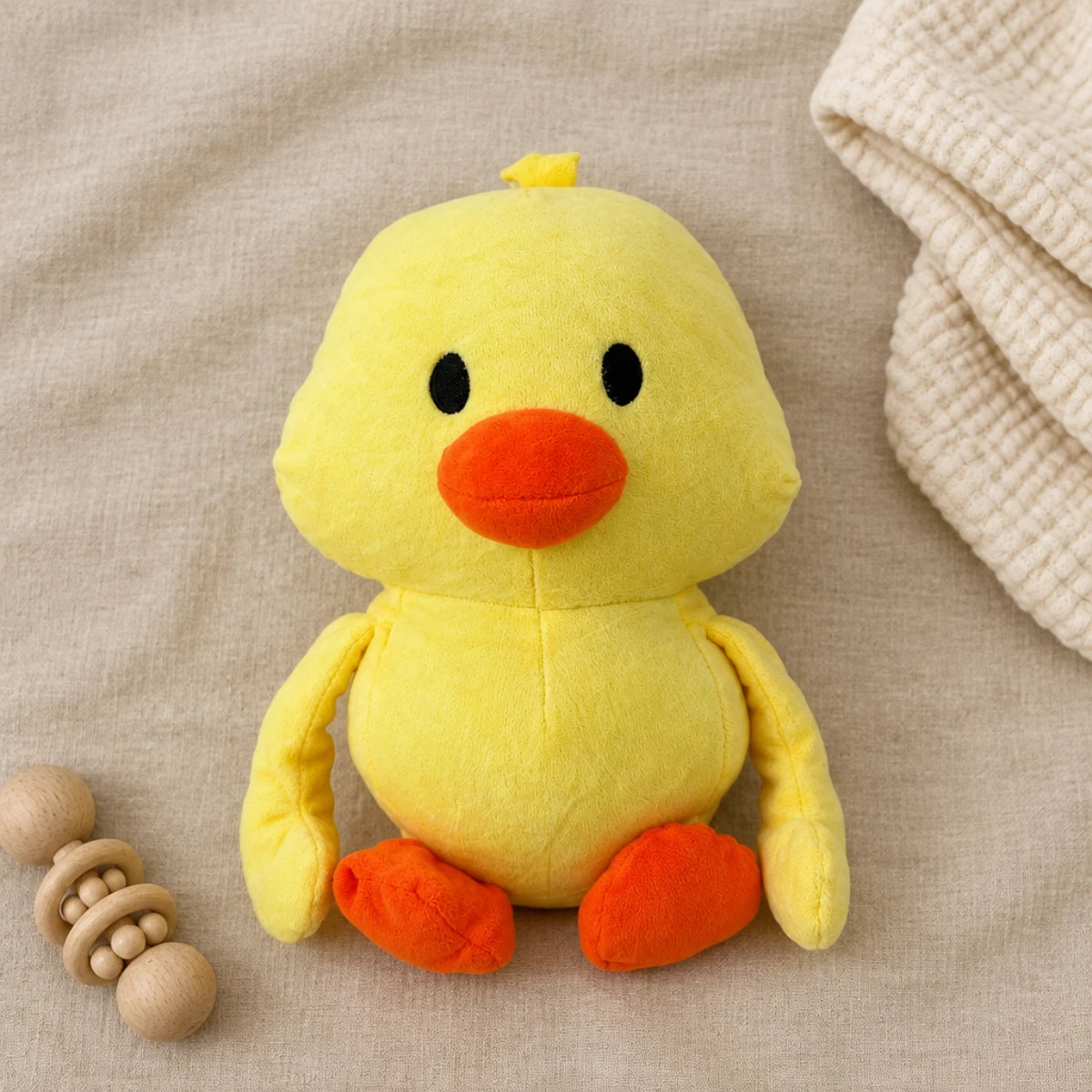 Yellow duck plush toy on neutral beige bedding beside a wooden toy