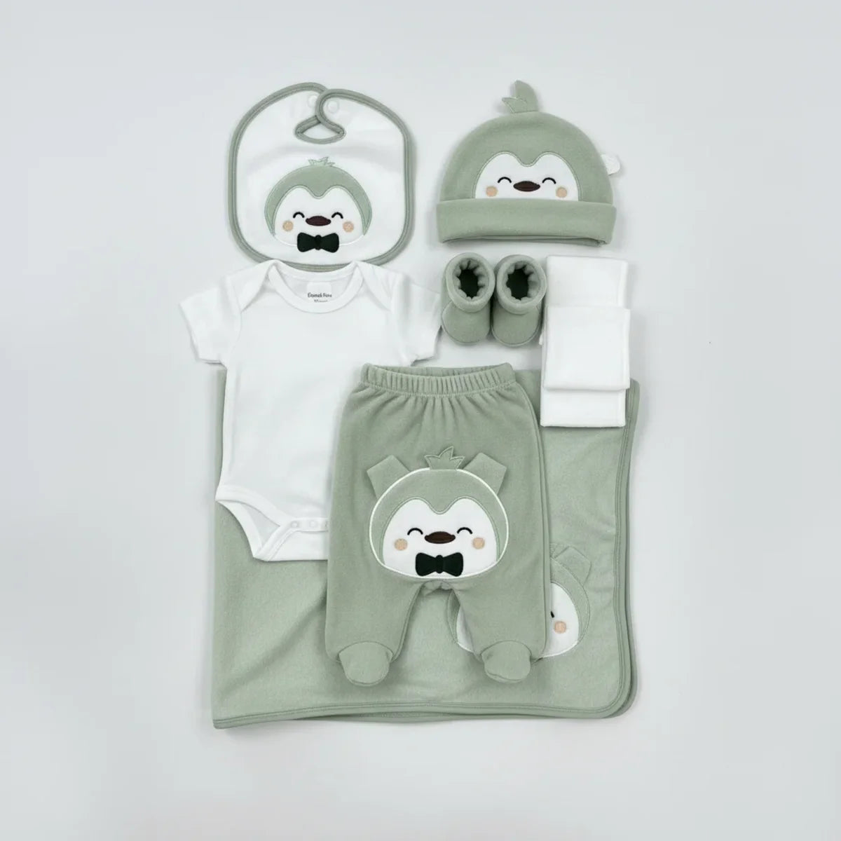 Elegant Kids Penguin Newborn Gift Set sage green and grey 7-piece hero shot on white background showing bodysuit on hanger footed trousers penguin hat bib booties blanket and muslin cloth with bow headband
