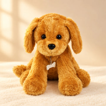 Golden retriever puppy plush toy studio scene on warm cream background with dappled natural sunlight showing full front view of fluffy golden caramel sitting puppy plush with long floppy ears two large glossy black bead eyes shiny black nose subtle smile long front paws and silver bone-shaped ID tag dangling at chest in natural sitting pose on white fluffy surface