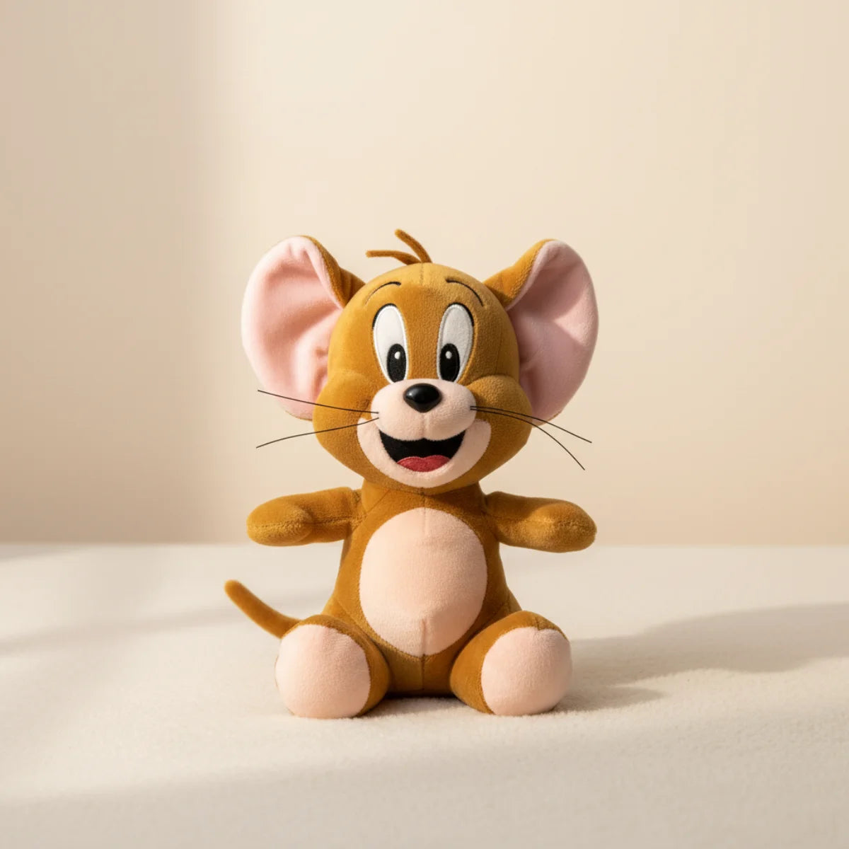 Jerry Mouse plush toy studio scene on soft warm cream gradient background showing full front three-quarter view of golden brown Tom and Jerry cartoon mouse plush with large pink inner ears wide cartoon eyes open smile pink tongue silver whiskers cream belly and round pink paw pads in arms-out sitting pose with soft natural shadow