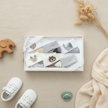 Baby Woodland Animal Socks 5 Pair Gift Box - lifestyle flat lay with baby shoes pacifier wooden elephant toy and dried flowers on linen