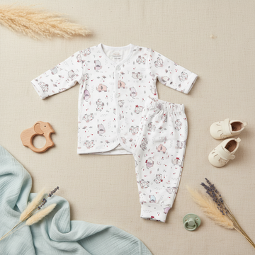 Happy Cosy Cartoon Monster Animal Print Baby Pyjama Set - lifestyle flat lay on white background showing short sleeve shirt and full-length trousers with all-over hippo elephant tiger cat print