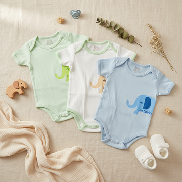 Little Home Baby I Love Daddy Elephant Bodysuit 3-Pack lifestyle flat lay beige linen with wooden elephant toy gray pacifier eucalyptus sprig dried flowers white baby shoes cream muslin cloth