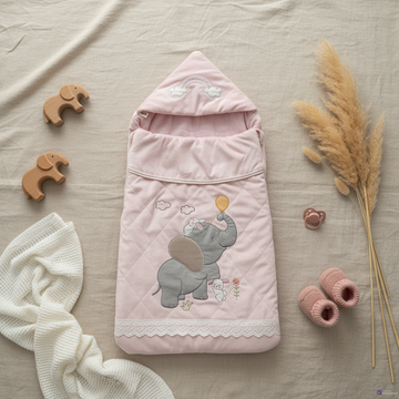 Pink elephant bunny baby sleeping bag – lifestyle flat lay with wooden elephant toys, pink booties and pampas grass