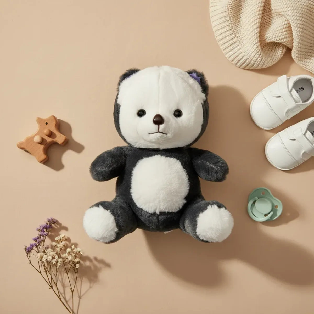 Pebble the Panda Bear plush toy flat lay with baby shoes pacifier and dried flowers