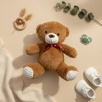 Honey the Classic Brown Teddy Bear flat lay with baby shoes pacifier and eucalyptus