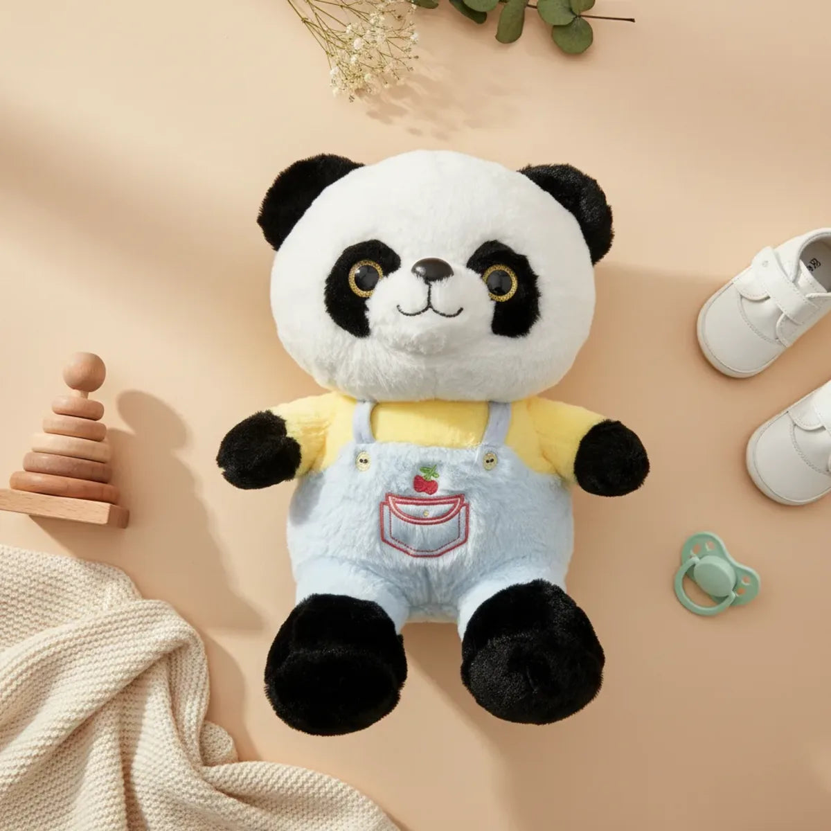 Bao the Dressed Panda plush toy flat lay with baby shoes wooden stacking toy and pacifier on beige background