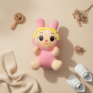Pink bunny girl plush doll – premium flat lay on beige background with wooden rattle, baby shoes, pacifier and dried flowers