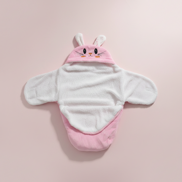 Pink bunny hooded swaddle wrap – premium studio scene on blush pink background showing 3D bunny ears and wrap detail