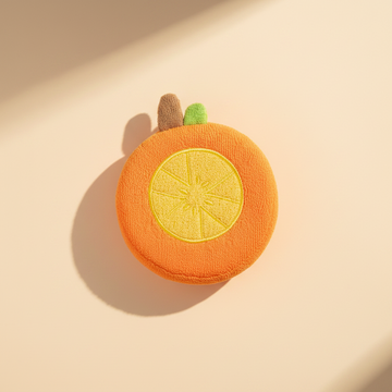 Orange slice baby bath sponge – premium studio scene on warm beige background with natural light shadow showing texture detail