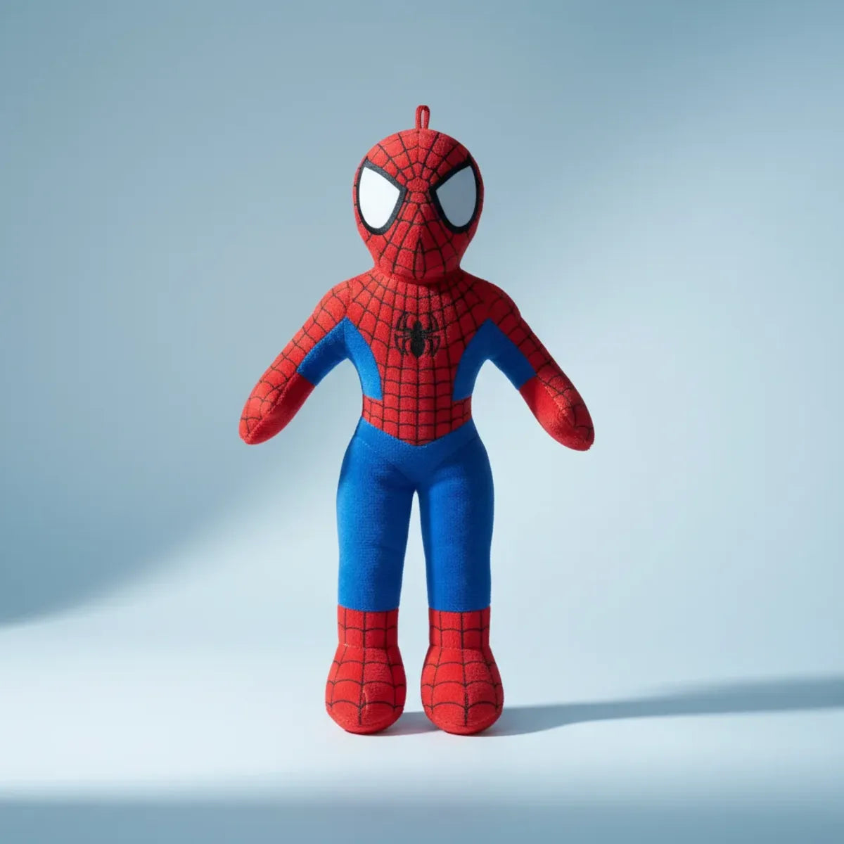 Red and blue web hero plush doll – studio shot on light blue background