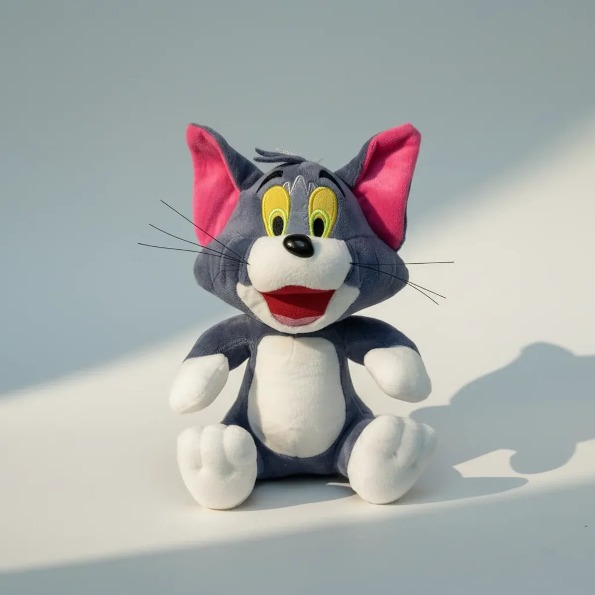 Whiskers grey cartoon cat plush toy studio shot on light blue background