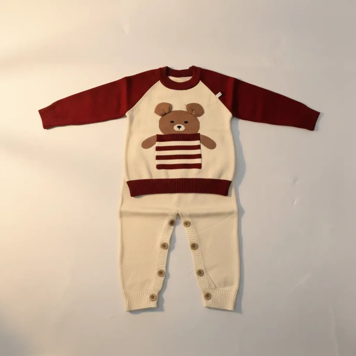 Teddy Bear Raglan Knit Set studio shot showing full outfit flat with button detail on cream trousers against light grey background