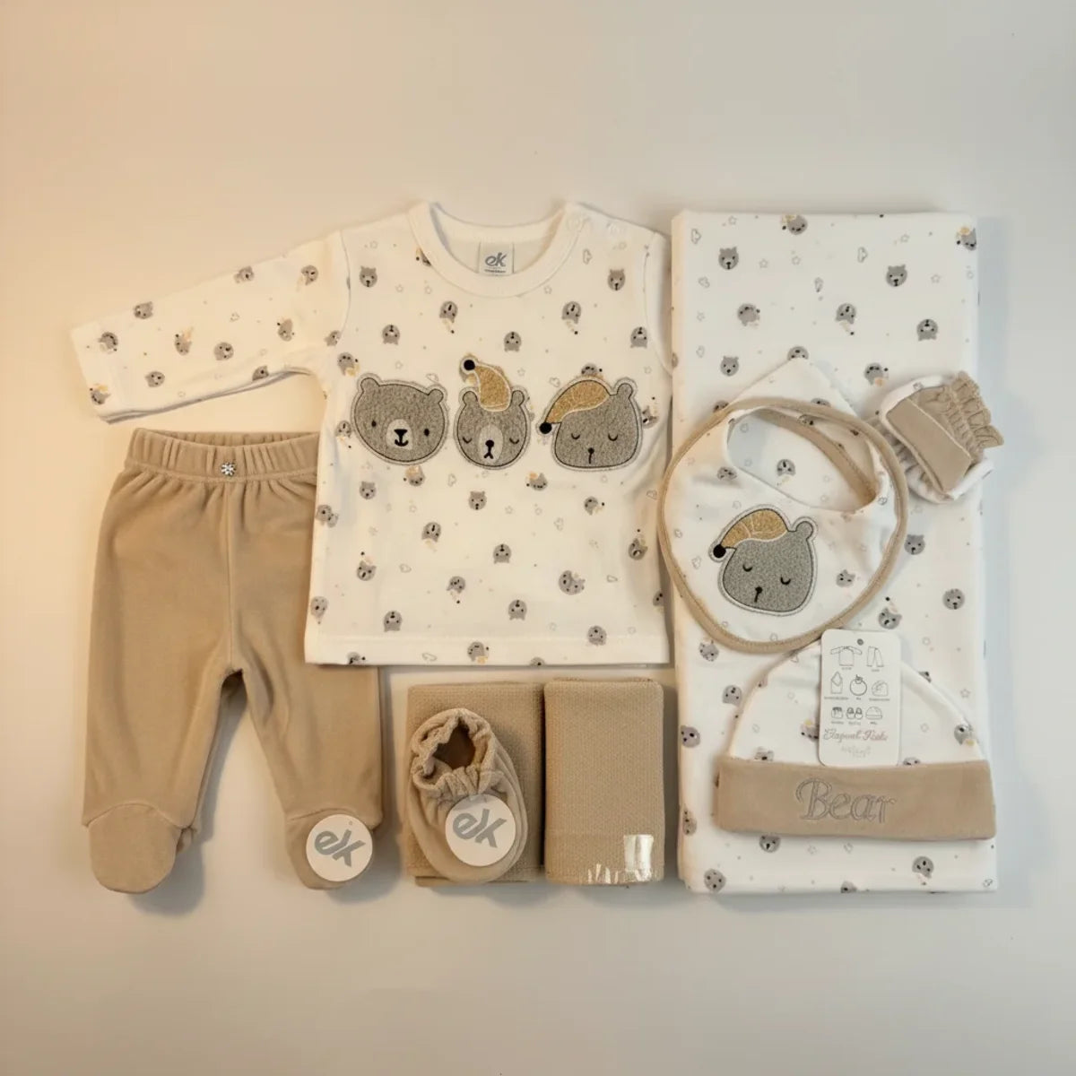 Bear Newborn Gift Set flat lay showing all 7 pieces including bodysuit trousers swaddle bib beanie and booties on cream background