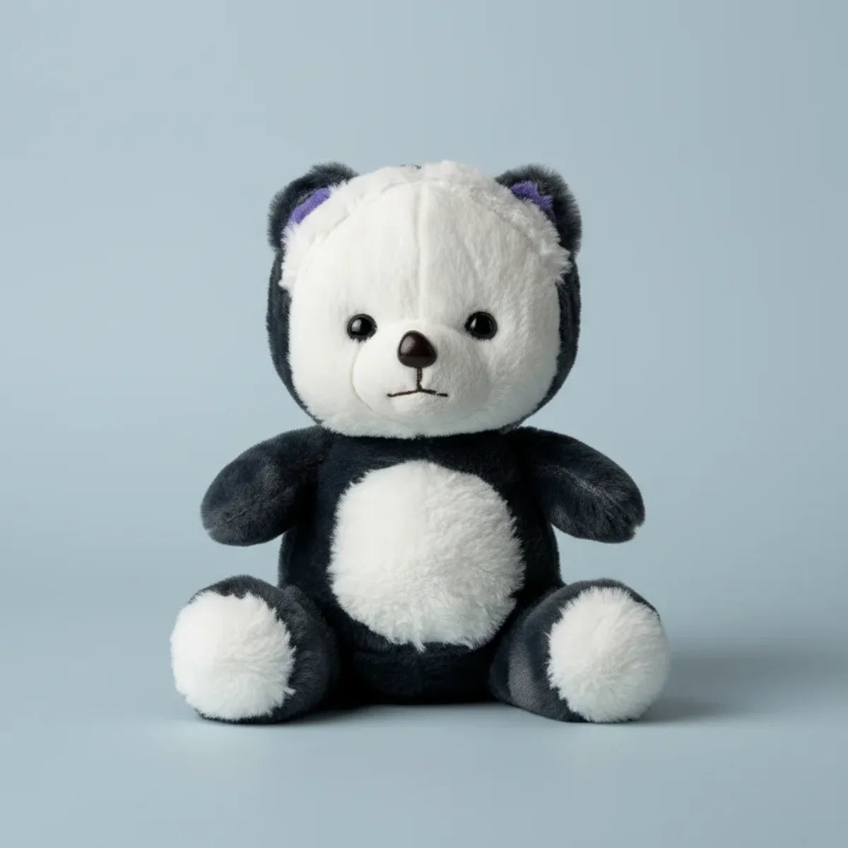 Pebble the Panda Bear plush toy studio shot on soft blue background