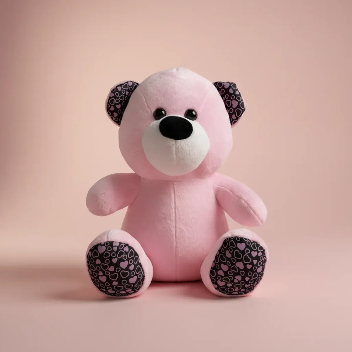 Rosie the Pink Heart Teddy Bear studio shot on blush pink background showing heart-print ears and paw pads