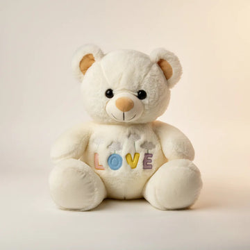 Luna the LOVE White Teddy Bear studio shot on cream background showing fluffy white coat and multicolour LOVE tummy appliqué