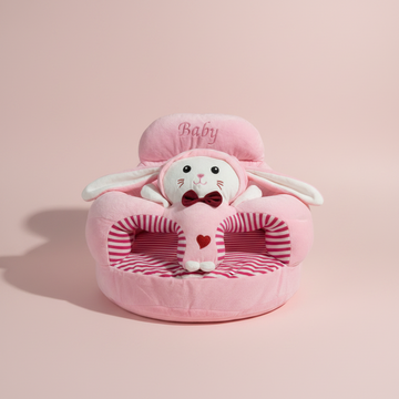 Pink bunny plush baby sitting support sofa – premium studio scene on pink background showing full sofa with white bunny face and red bow tie
