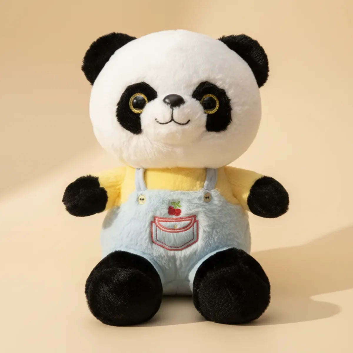 Bao the Dressed Panda plush toy studio shot showing yellow top and blue denim dungarees with cherry pocket