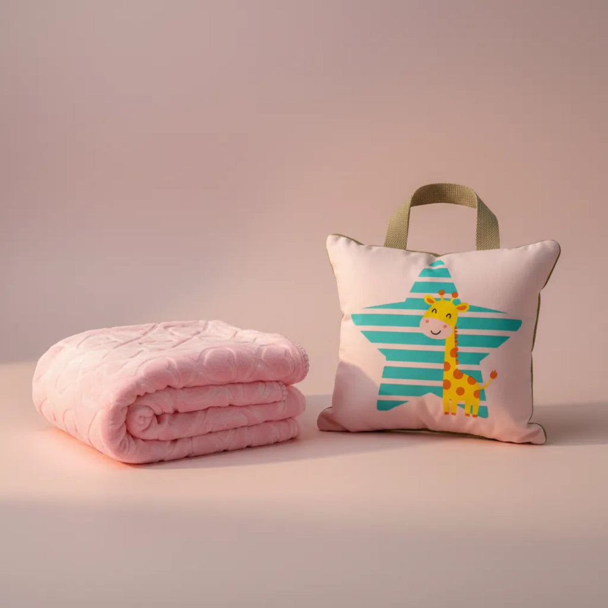 Giraffe Star Baby Gift Set showing pink quilted blanket rolled and giraffe star tote cushion on blush pink background