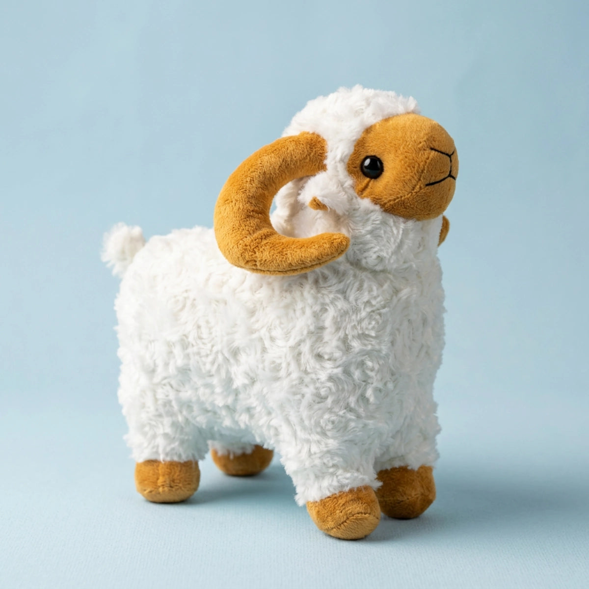 Standing white ram plush with golden curled horns against a pale blue background