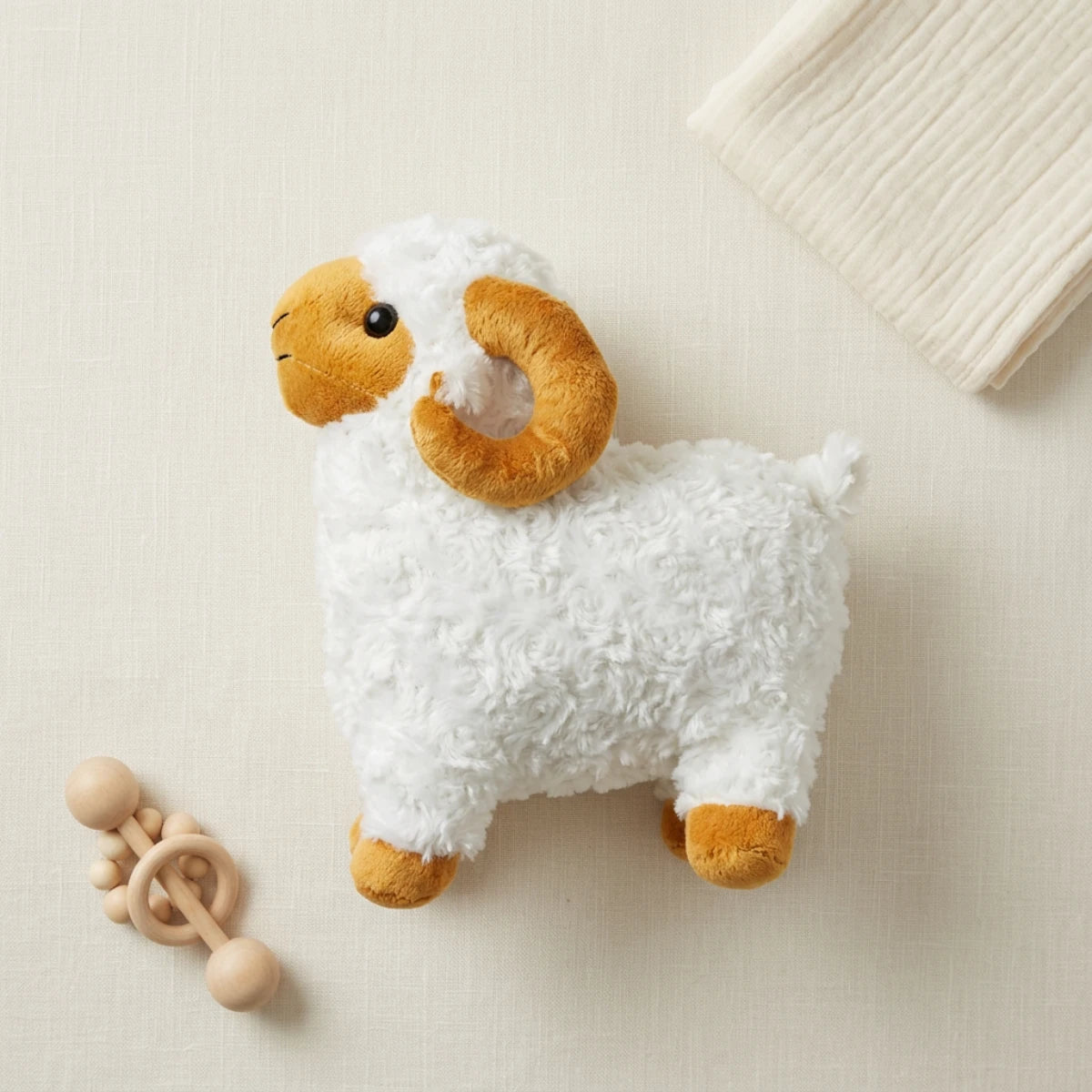 White ram plush shown from the side on ivory linen