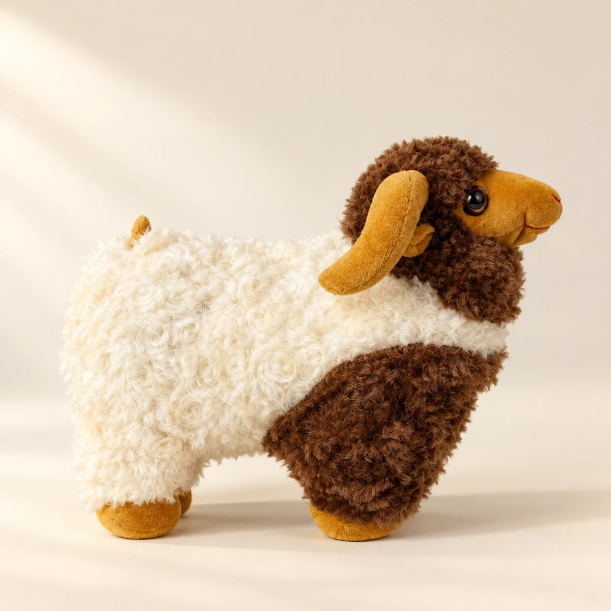 Brown and cream ram plush toy shown from the side in a studio setting