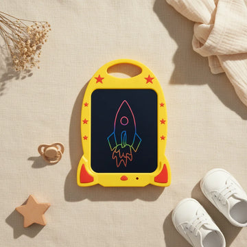 Yellow Rocket Ship 15 inch LCD Writing Tablet showing rainbow colour rocket drawing on screen with red star accents and carry handle on linen background with wooden star pacifier and white baby shoes
